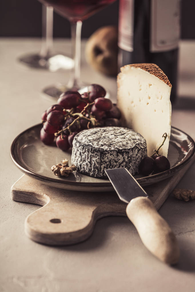 Κόκκινο κρασί και τυρί πιάτο με φρούτα και ξηρούς καρπούς - Φωτογραφία, εικόνα