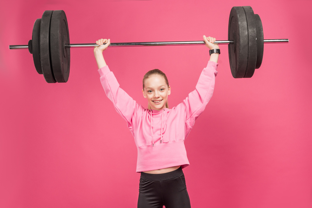 atlético feminino preteen trabalhar fora com barbell, isolado no rosa
 - Foto, Imagem