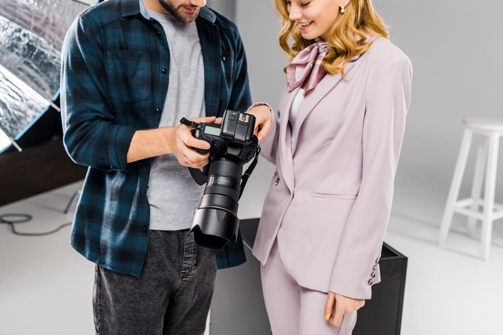 genç fotoğrafçı ve birlikte fotoğraf makinesi kullanarak modeli gülen in atış kırpılmış - Fotoğraf, Görsel