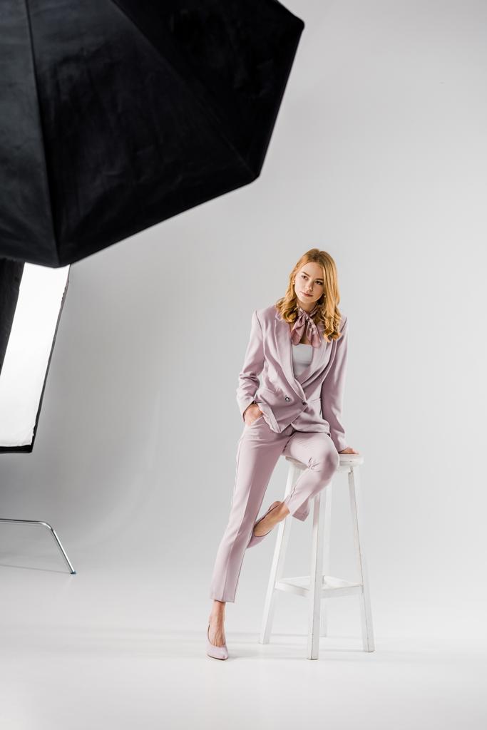 写真スタジオでポーズをとってピンクのスーツで美しい若いモデル - 写真・画像
