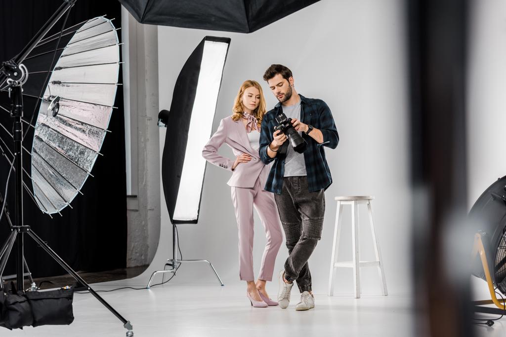 young photographer and model checking photos on camera in studio - Photo, Image