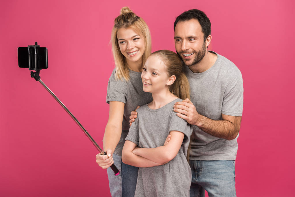 belle famille heureuse prenant selfie sur smartphone, isolé sur rose
 - Photo, image
