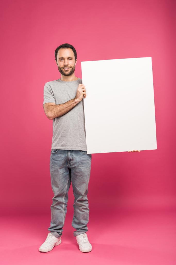 handsome man posing with blank board, isolated on pink - Photo, Image
