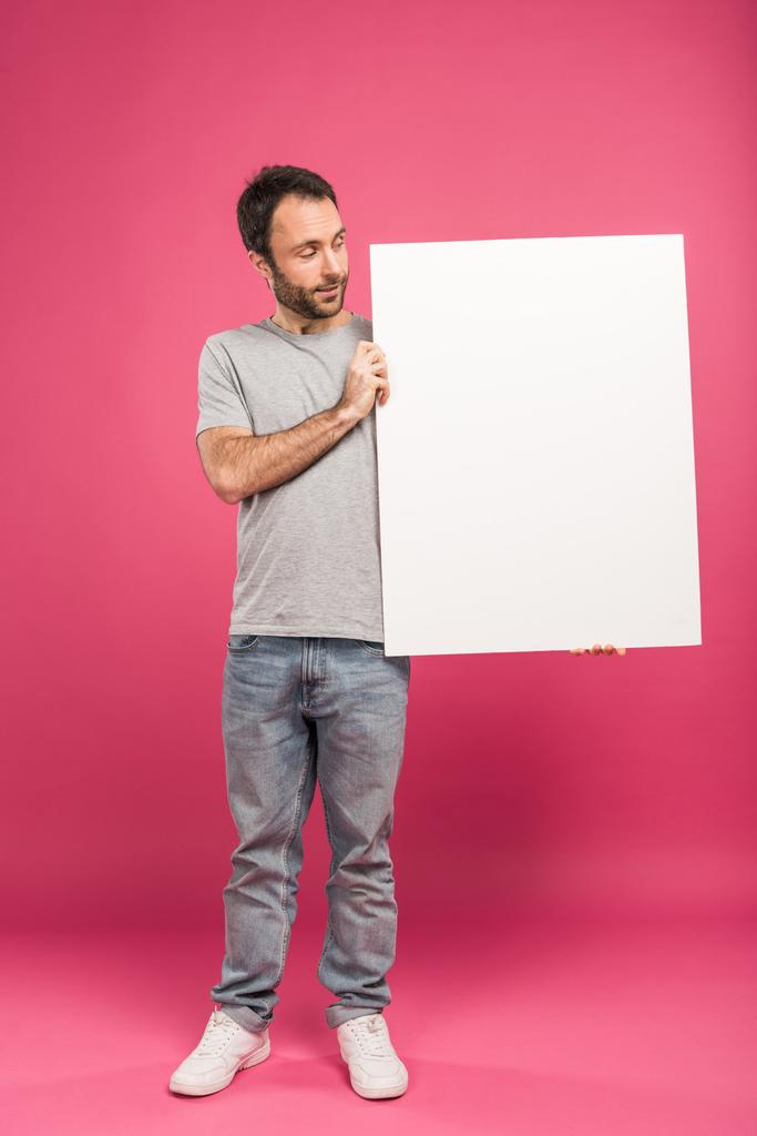 handsome adult man holding blank board, isolated on pink - Photo, Image