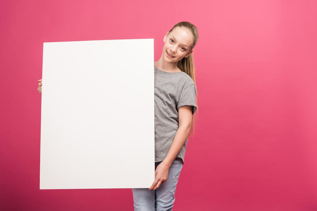schattig kind poseren met een leeg bord, geïsoleerd op roze - Foto, afbeelding