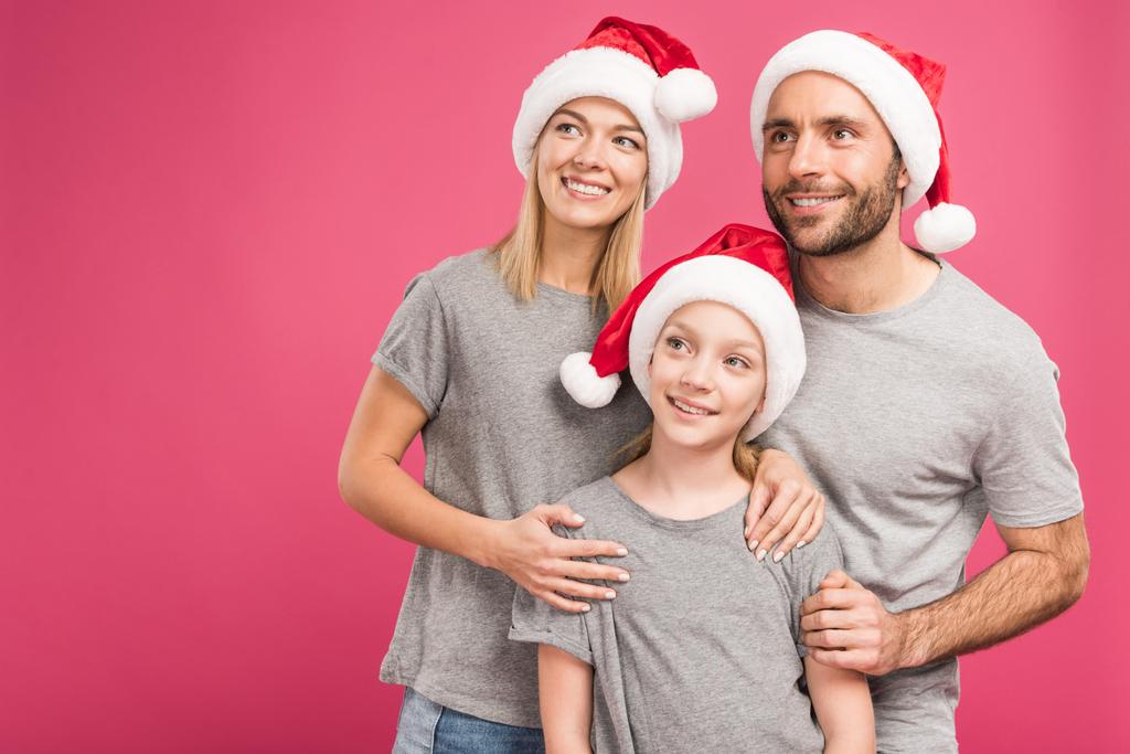 ritratto di genitori felici con adorabile figlia in cappelli di Babbo Natale, isolato su rosa
 - Foto, immagini