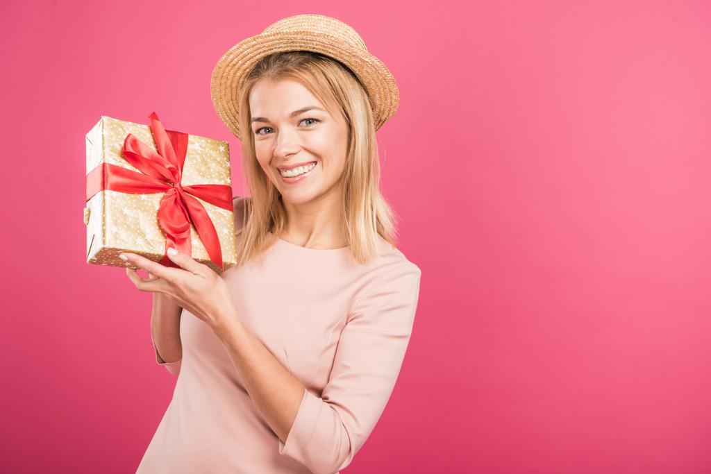 attractive blonde woman in straw hat holding gift isolated on pink  - Photo, Image