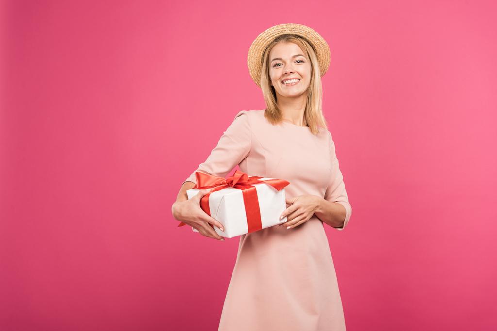 fröhliche Frau hält Geschenkbox isoliert auf rosa  - Foto, Bild