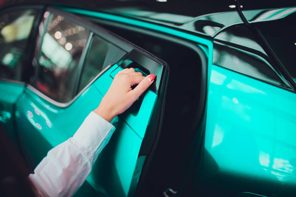weibliche Hand für den Einsatz hintere Tür offen Auto beige Farbe. für Transport und Automobilimage - Foto, Bild