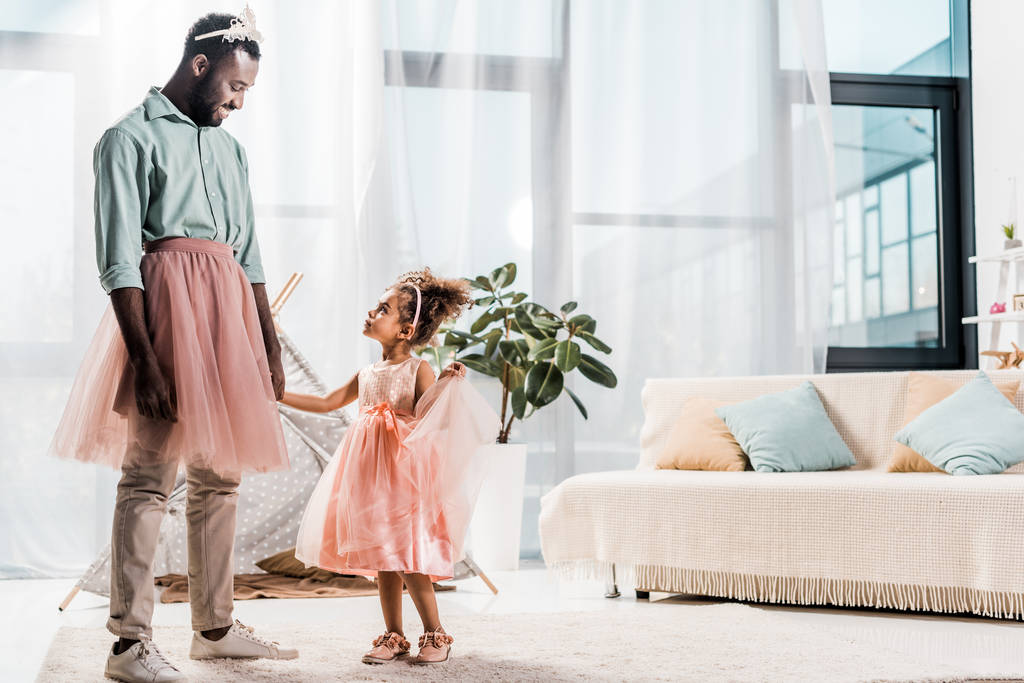 boldog afro-amerikai apa nézte aranyos lánya, a gyönyörű ruha  - Fotó, kép