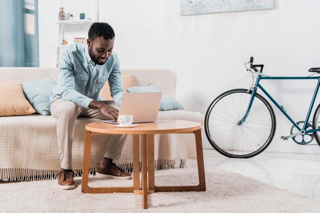 afro-amerikai szabadúszó ül a kanapén, és használ laptop - Fotó, kép