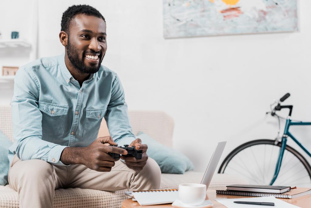 アフリカ系アメリカ人のジョイスティックを自宅でビデオ ゲームをプレイ - 写真・画像