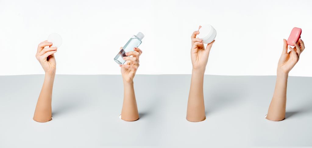 oříznuté záběr ženy držící mýdlo, vatovým tampónkem, mléko a smetanu skrz otvory na bílém - Fotografie, Obrázek