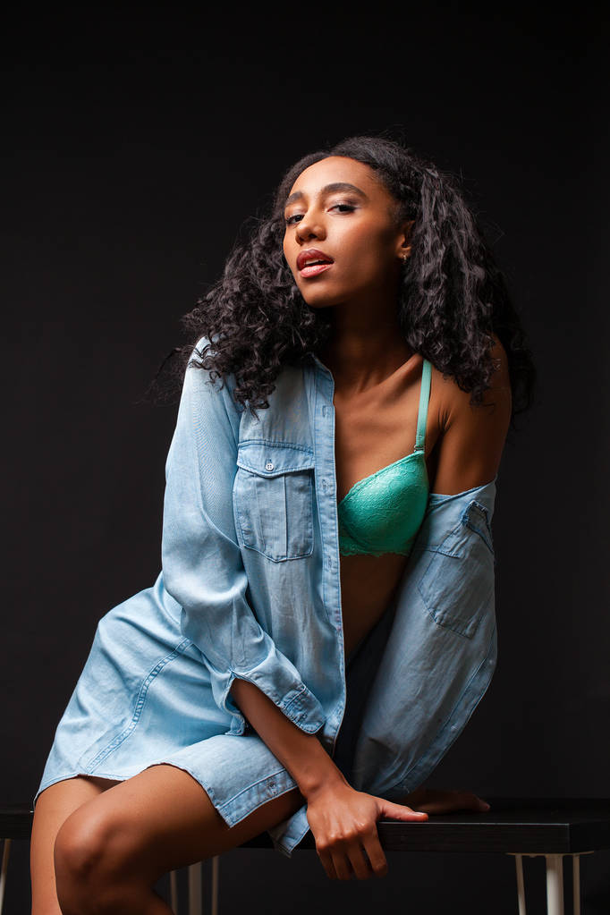 Sexy bella donna africana americana in posa in camicia blu, Scuro Studio colpo
. - Foto, immagini