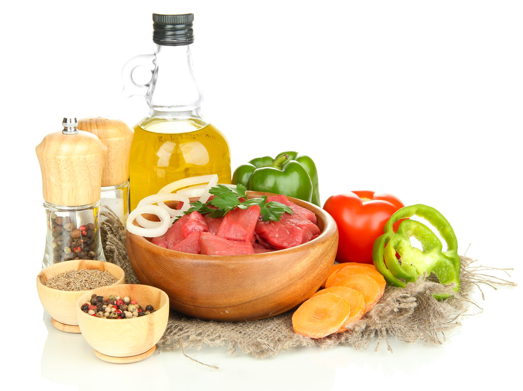 Carne di manzo cruda in ciotola con erbe aromatiche, spezie e olio da cucina isolato su bianco
 - Foto, immagini