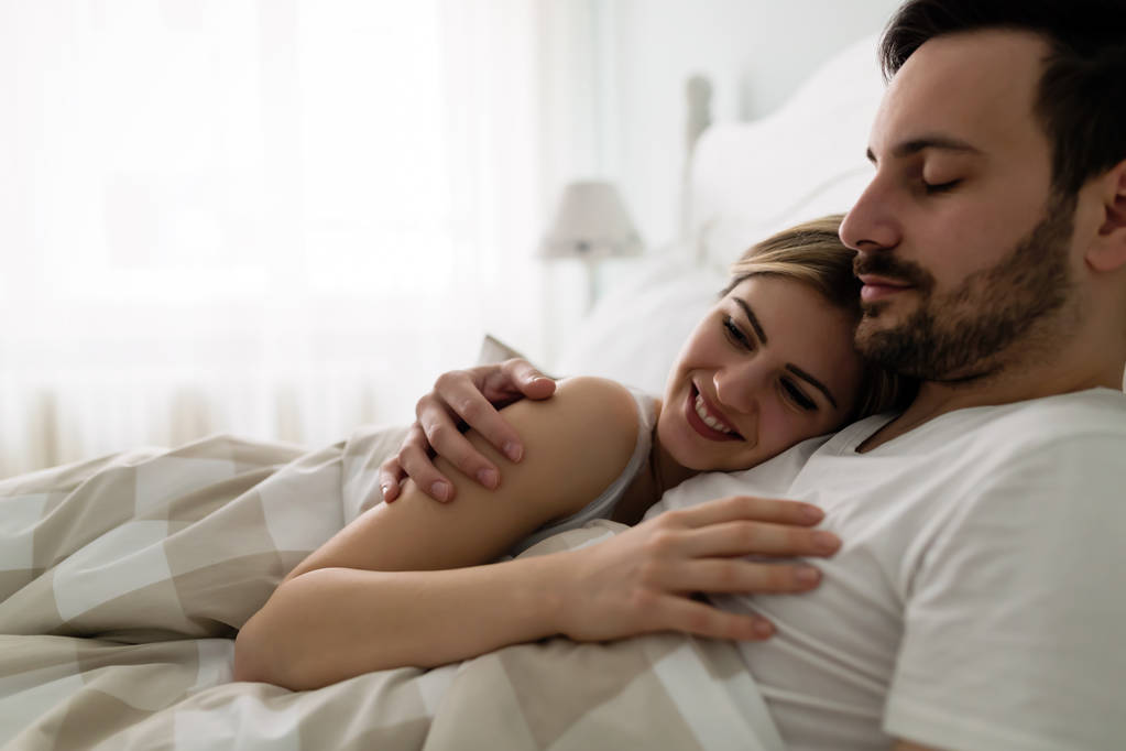 Молодая привлекательная счастливая пара, имеющая романтическое время в постели
 - Фото, изображение