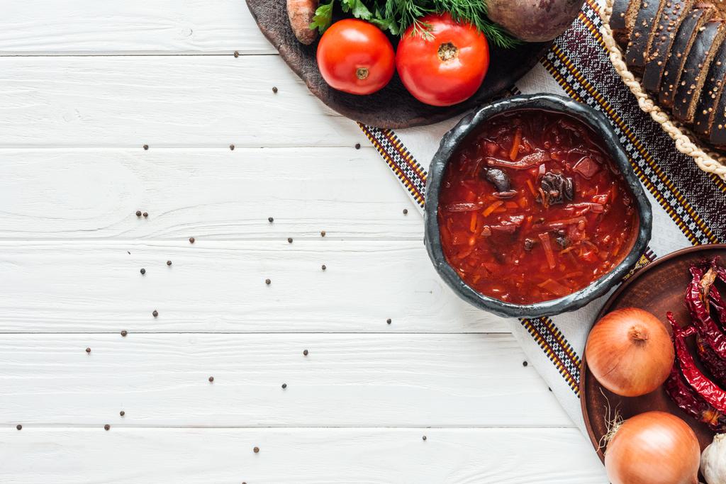 traditionele rode bieten soep met ingrediënten en piment op witte houten achtergrond met kopie ruimte - Foto, afbeelding