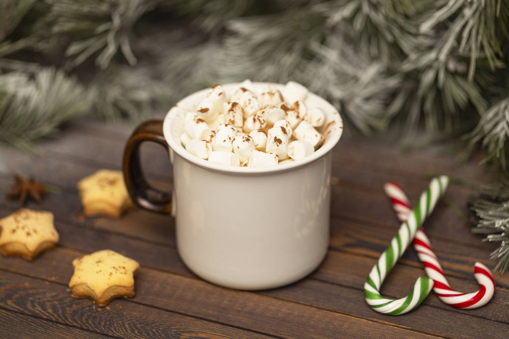 Зимовий гарячий різдвяний шоколад або какао з зефіром з прикрасами. Чашка гарячого шоколаду з зефіром та пряниками на різдвяному столі
. - Фото, зображення