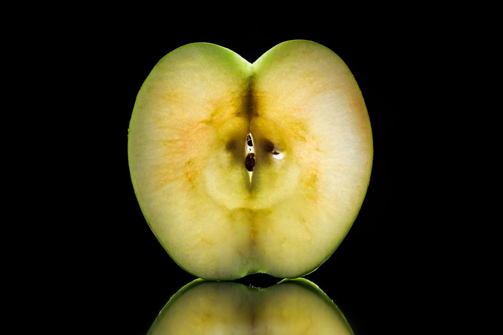 połowa z surowego dojrzałe jabłko na czarnym tle - Zdjęcie, obraz