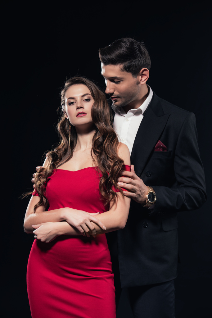 homme embrassant femme attrayante en robe rouge isolé sur noir
 - Photo, image