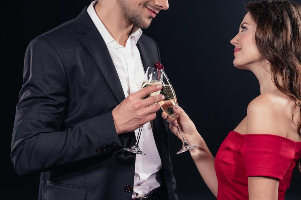 feliz pareja brindis con copas de champán aisladas en negro
 - Foto, imagen