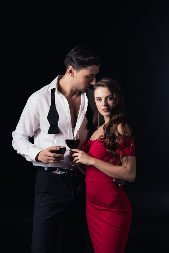 attraente coppia tenendo bicchieri di vino rosso isolato su nero
 - Foto, immagini
