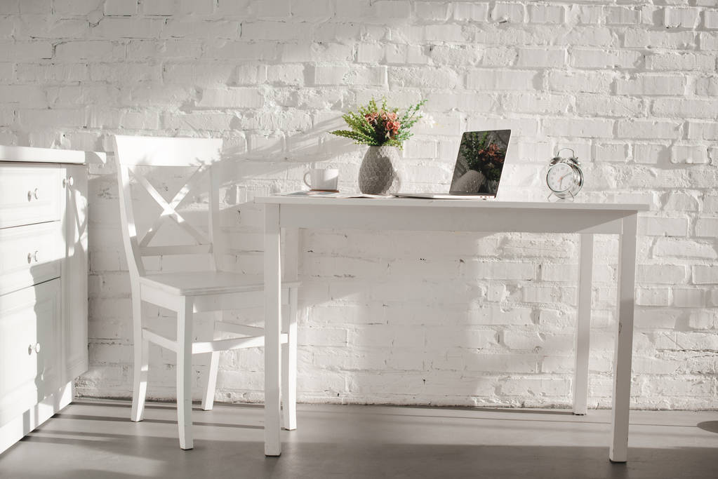 laptop közelében kupa és váza fehér konyha konyha virág  - Fotó, kép