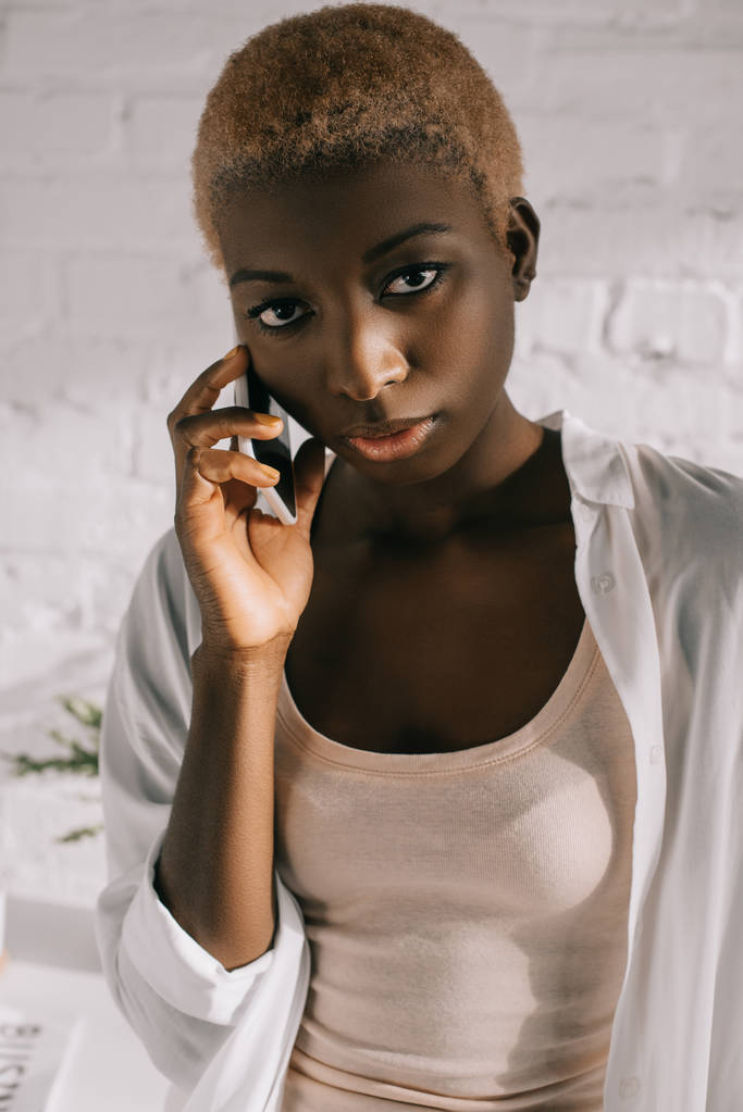 κοντινό πλάνο της αφρικανική αμερικανική γυναίκα με κοντά μαλλιά μιλάμε για smartphone - Φωτογραφία, εικόνα