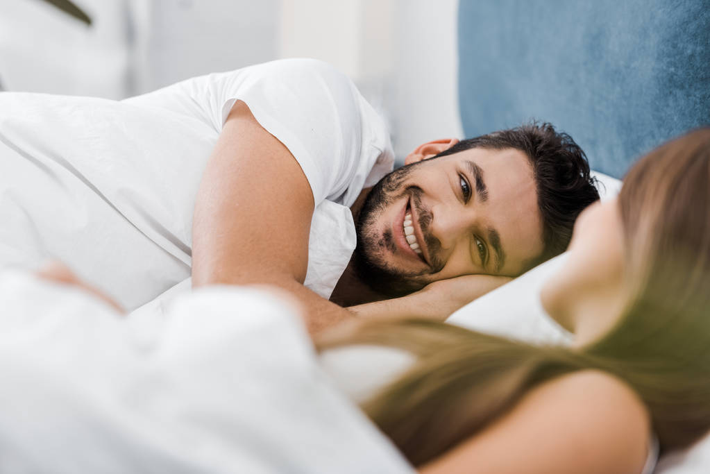 sorrindo jovem deitado na cama com a namorada
 - Foto, Imagem