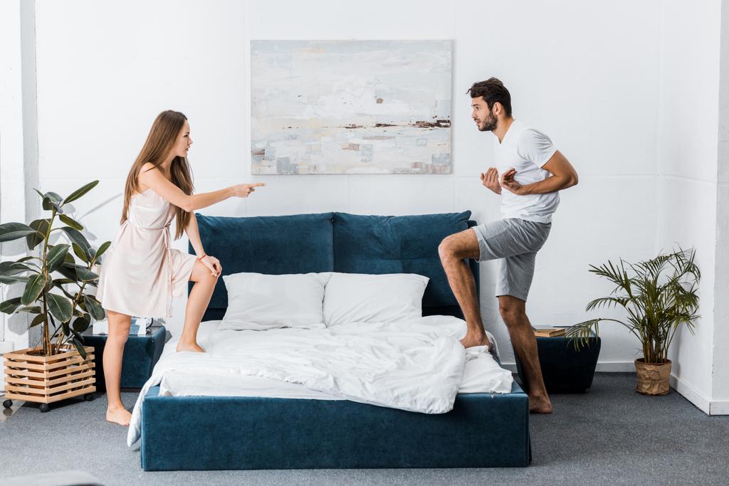 joven emocional pareja disputa enojado y gesto en el dormitorio
 - Foto, imagen