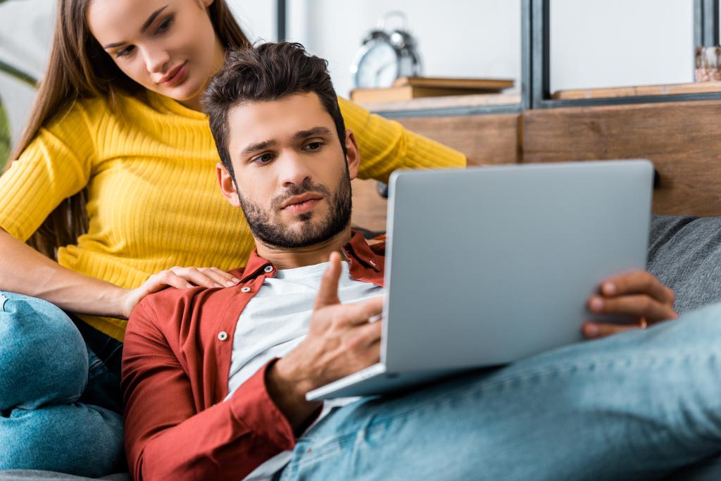 молода орієнтована пара сидить і дивиться на ноутбук
 - Фото, зображення
