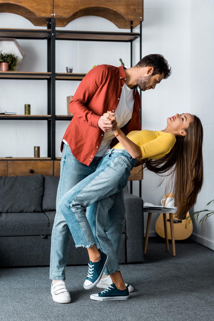  bell'uomo barbuto che balla con la fidanzata attraente in soggiorno
 - Foto, immagini