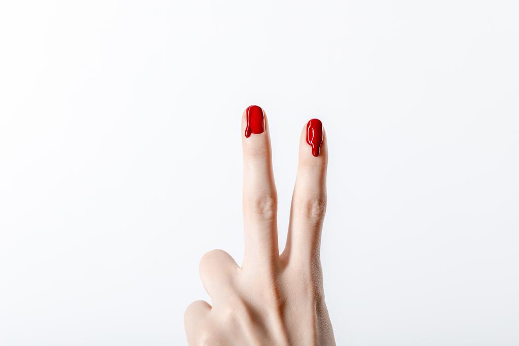 обрізаний вид жінки, що показує знак миру з крапельним червоним лаком для нігтів ізольовано на сірому
 - Фото, зображення