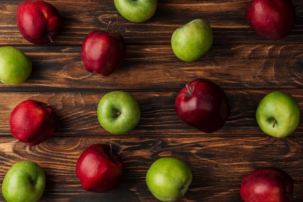 верхний вид спелых красных и зеленых яблок на деревянный стол
 - Фото, изображение