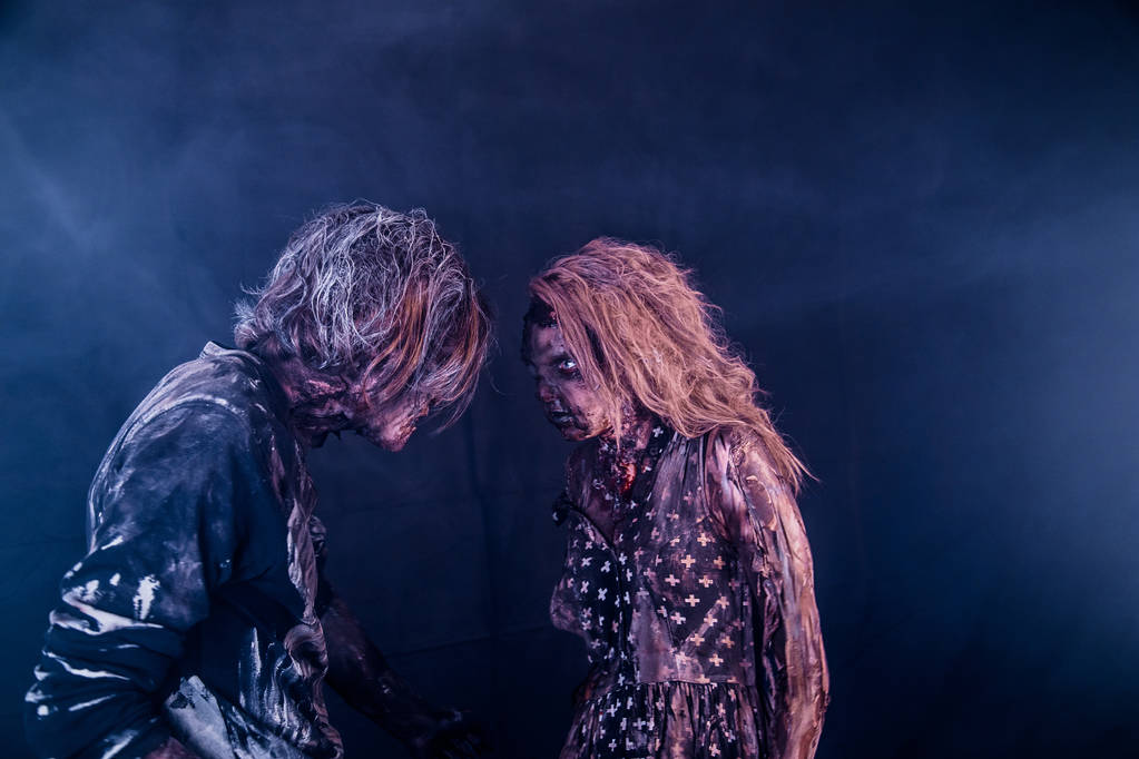 Zombie coppia posa insieme contro nebbioso sfondo scuro
 - Foto, immagini