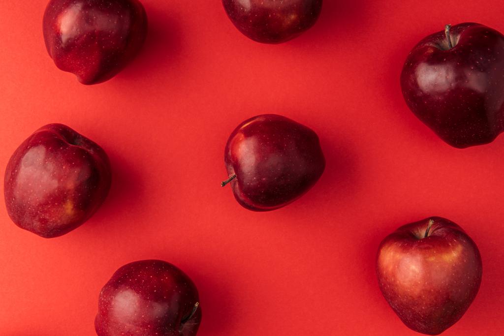 вид сверху на вкусные большие яблоки на красном фоне
 - Фото, изображение