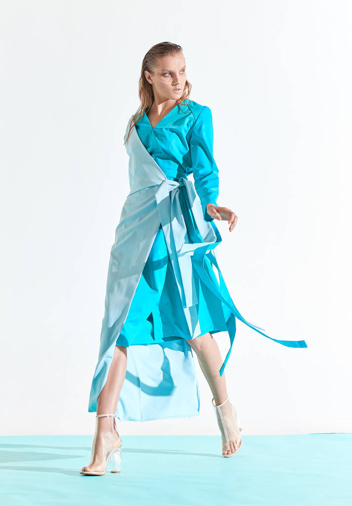 Volledige lengte mode portret van de jonge vrouw weared in turquoise en blauwe jurk. Studio, witte achtergrond  - Foto, afbeelding