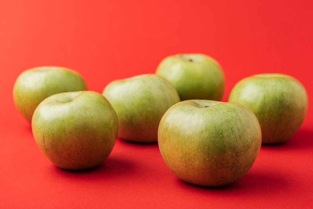 большие спелые зеленые яблоки на красном фоне
 - Фото, изображение