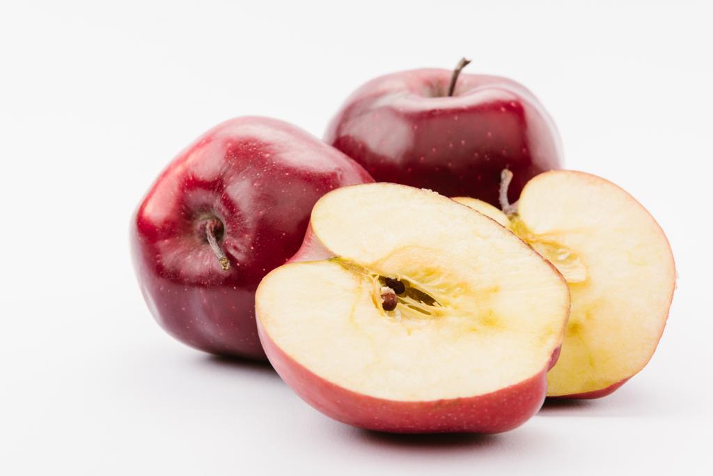 halved and whole tasty red apples on white background - Photo, Image