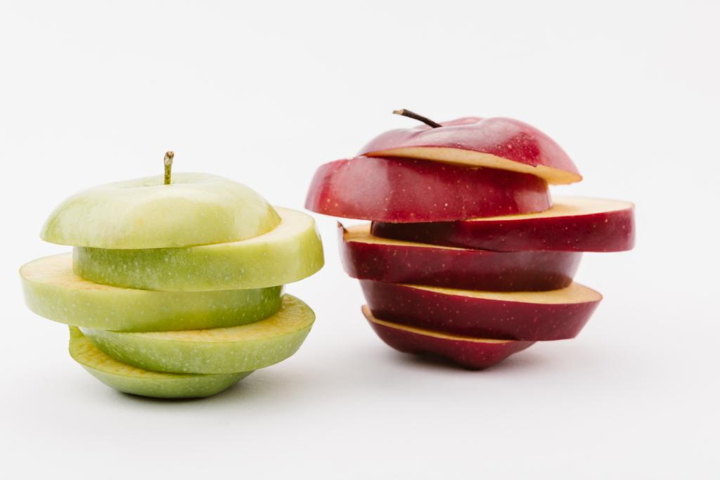 нарезанные золотые и красные вкусные яблоки на белом фоне
 - Фото, изображение