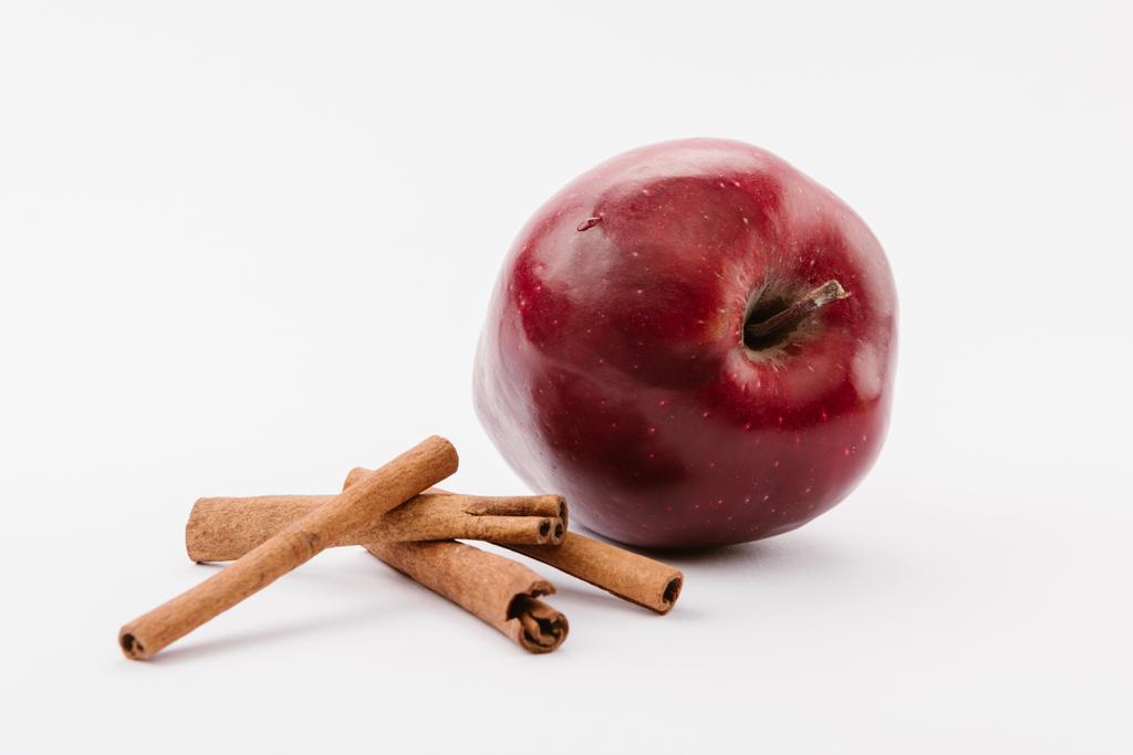 suuri punainen herkullinen omena ja kaneli valkoisella taustalla
 - Valokuva, kuva