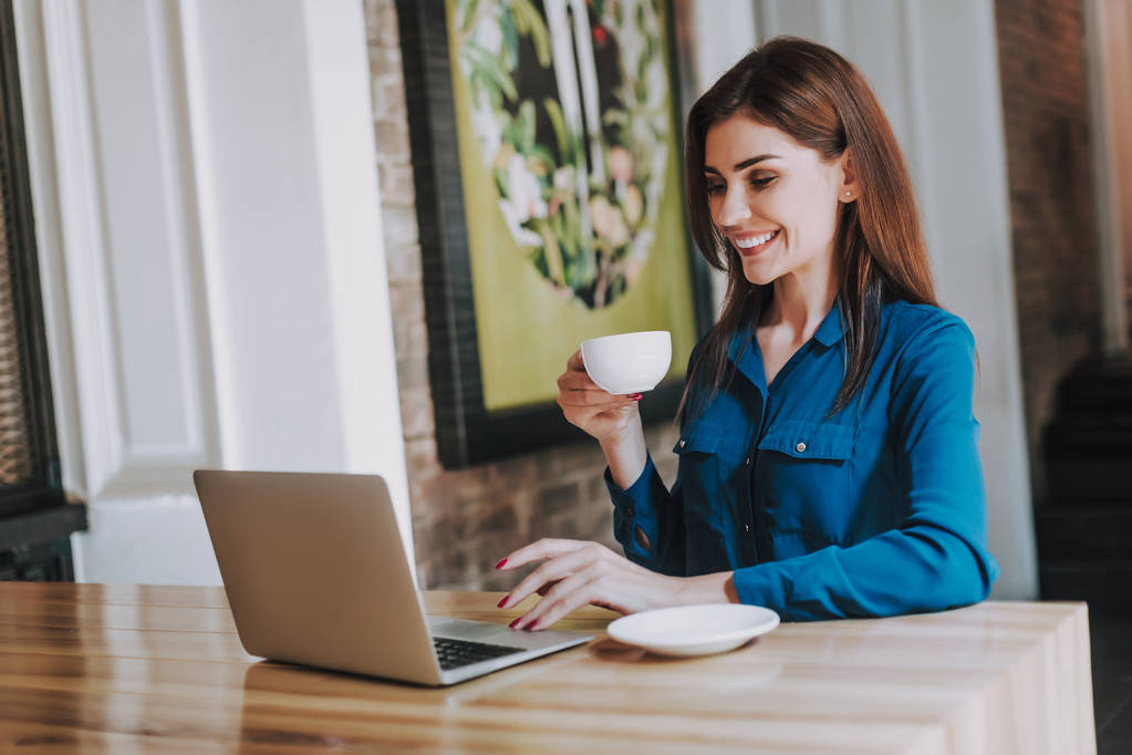 Donna d'affari felice digitando sul computer portatile in caffè
 - Foto, immagini