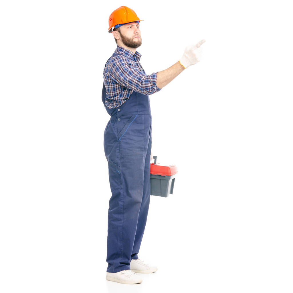 Молодой человек строитель с инструментальной промышленности рабочая каска показ
 - Фото, изображение