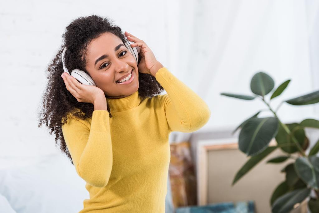 portret młodego african american kobieta słuchania muzyki w słuchawkach - Zdjęcie, obraz