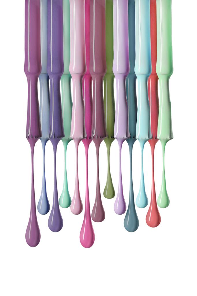 borstels met druipende en kleurrijke nail polish geïsoleerd op wit - Foto, afbeelding