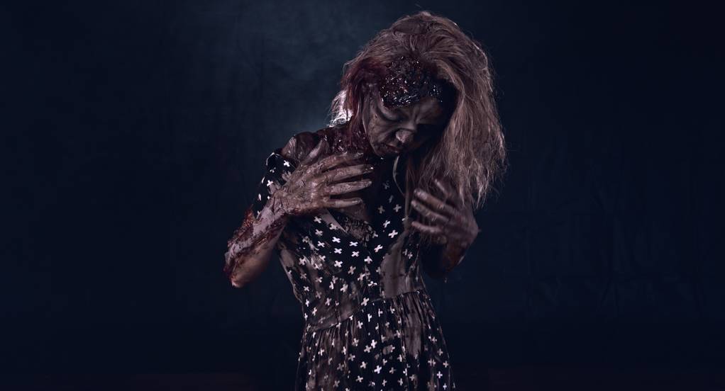 Моторошна зомбі жінка позує на темному тлі
 - Фото, зображення