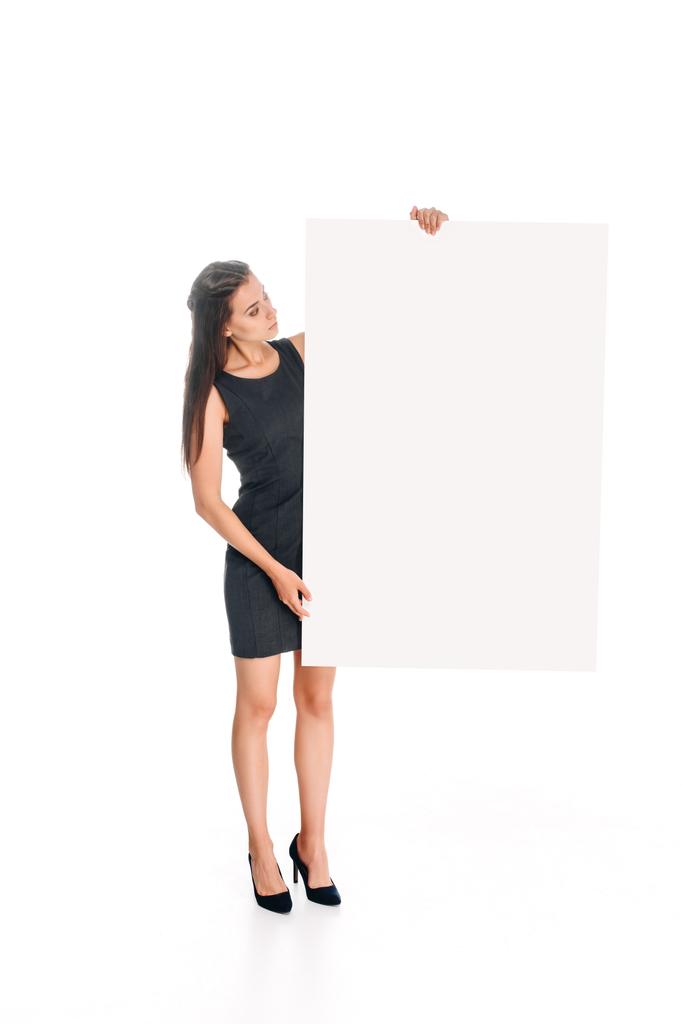 mujer en vestido negro mirando la pancarta en blanco en las manos aisladas en blanco
 - Foto, imagen