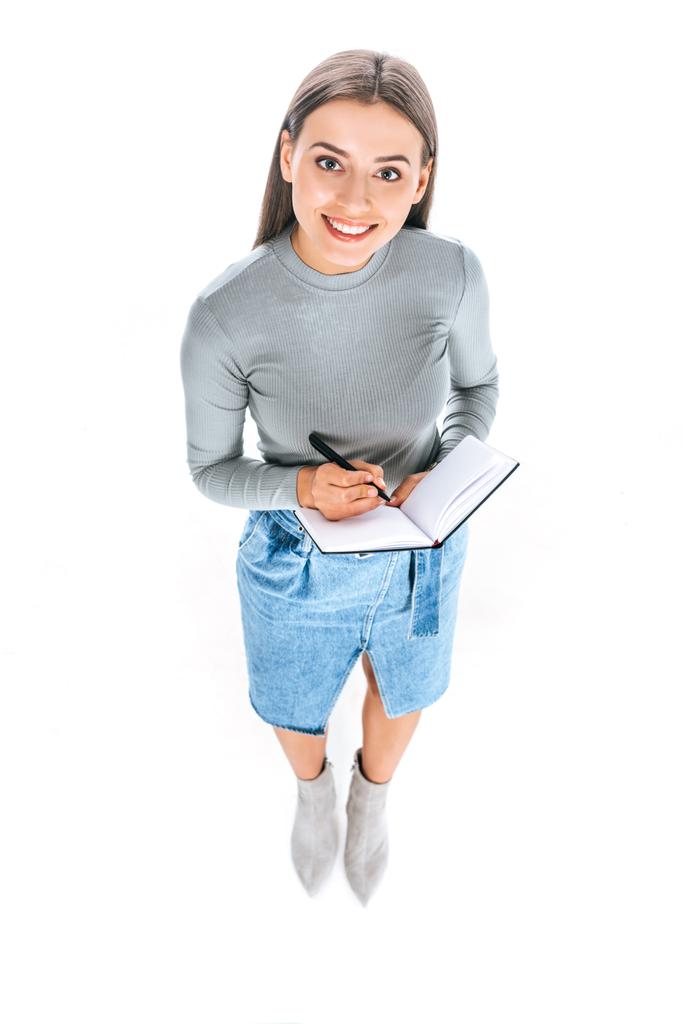 vue grand angle de la femme souriante avec cahier et stylo isolé sur blanc
 - Photo, image