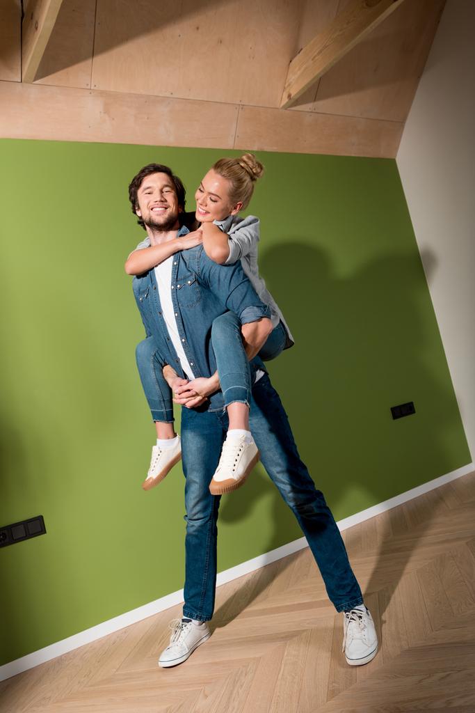 sorrindo homem dando passeio de piggyback para menina alegre no apartamento
 - Foto, Imagem