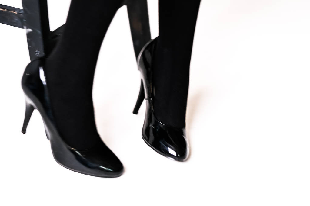 női láb fekete harisnya és harisnya, fekete magas sarkú cipő  - Fotó, kép
